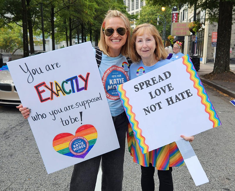 School board candidate Katie McRee and volunteer Peggy with signs of support at Gay Pride Parade in Atlanta 2022